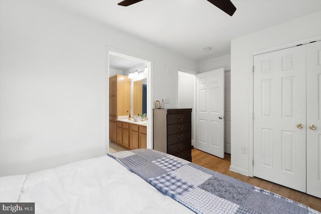 bedroom featuring ensuite bathroom, ceiling fan, wood-type flooring, and a closet