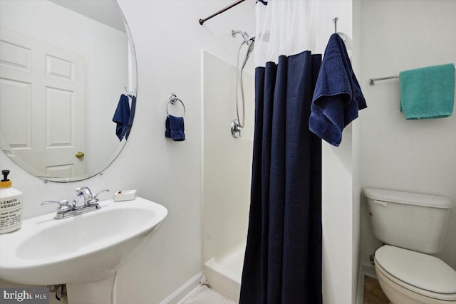 bathroom featuring a shower with curtain, toilet, and sink