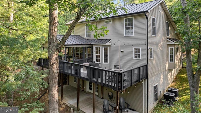 back of house with central AC unit and a wooden deck