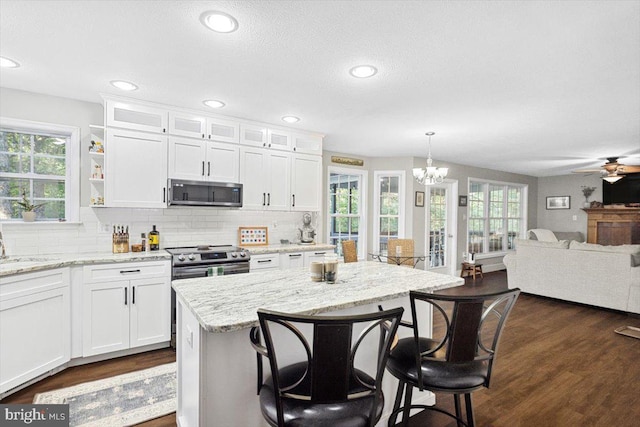 kitchen with white cabinets, a healthy amount of sunlight, decorative light fixtures, and appliances with stainless steel finishes