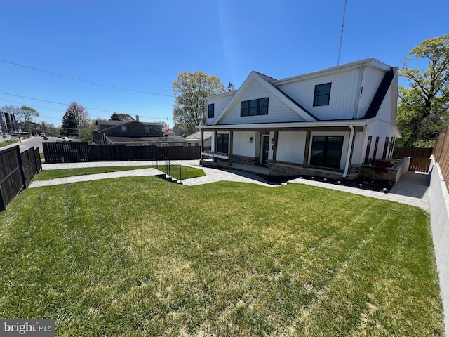 view of front facade featuring a front yard, a fenced backyard, and a patio area