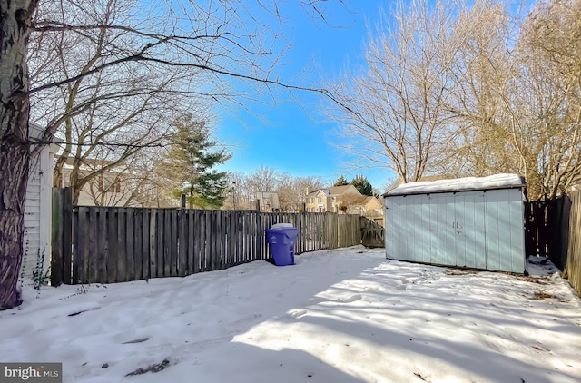 yard layered in snow with a storage unit