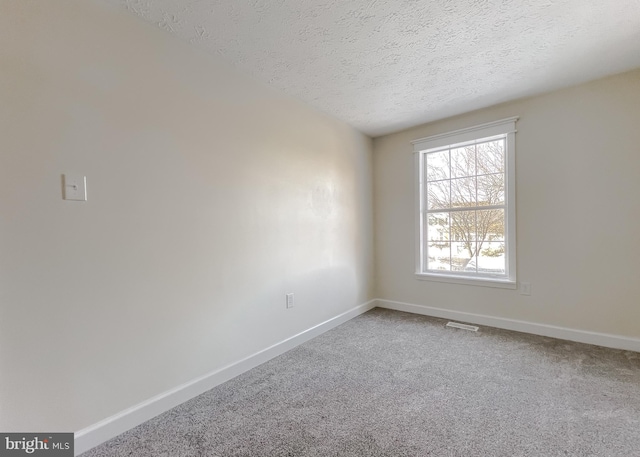 unfurnished room with a textured ceiling and carpet floors