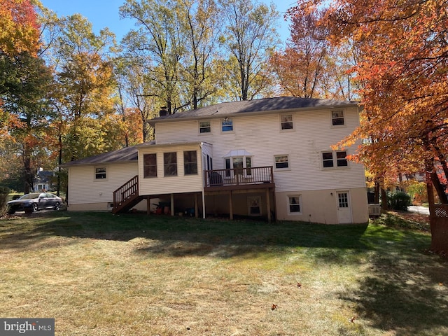 back of house with a deck, a sunroom, and a lawn