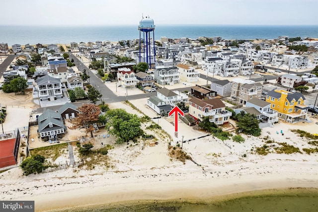 birds eye view of property featuring a beach view and a water view