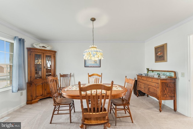 dining room featuring crown molding, baseboards, visible vents, and light colored carpet