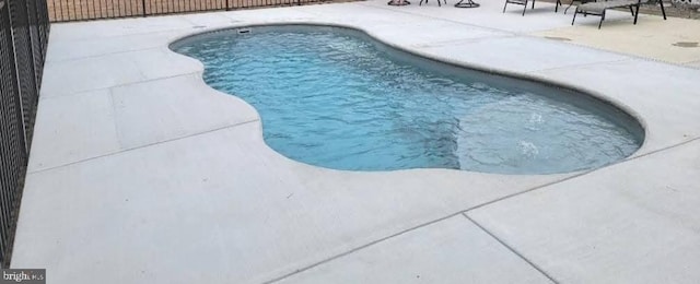 view of swimming pool with a patio area, fence, and a fenced in pool