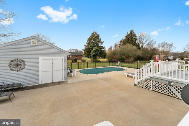 view of pool with a patio, fence, a wooden deck, and a fenced in pool