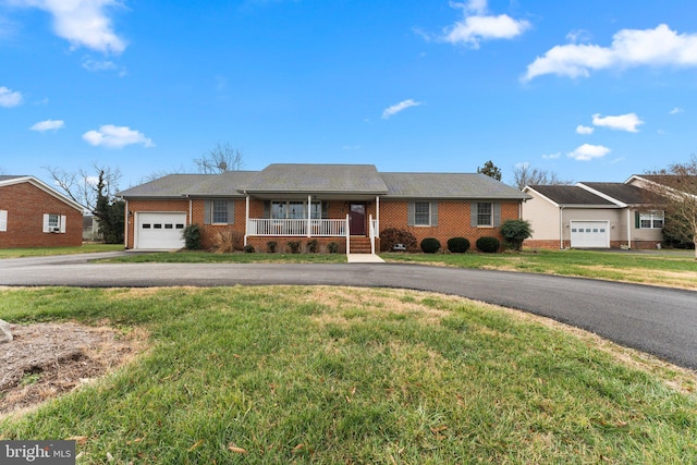 ranch-style house featuring covered porch, a garage, brick siding, driveway, and a front lawn