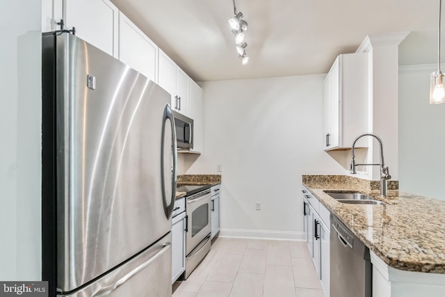 kitchen with appliances with stainless steel finishes, sink, pendant lighting, stone counters, and white cabinets