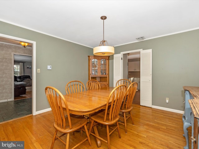 dining area featuring light hardwood / wood-style floors and crown molding