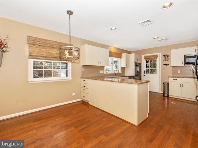 kitchen featuring backsplash, kitchen peninsula, sink, and white cabinets