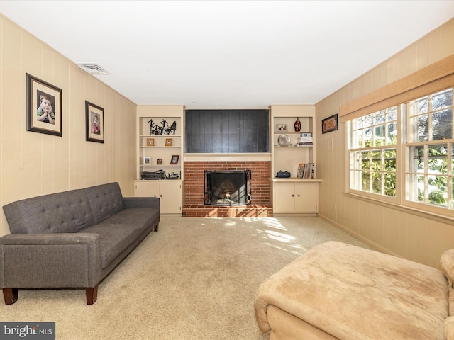 carpeted living room featuring a fireplace, built in shelves, and wood walls