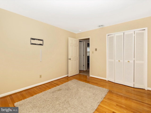 unfurnished bedroom with hardwood / wood-style floors and a closet