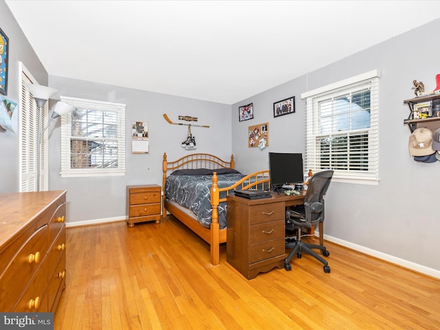 bedroom with multiple windows and light wood-type flooring