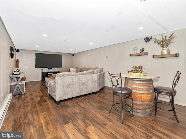 living room featuring wood walls, dark hardwood / wood-style flooring, and baseboard heating