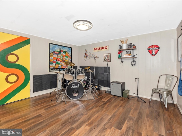 recreation room featuring dark wood-type flooring and wooden walls