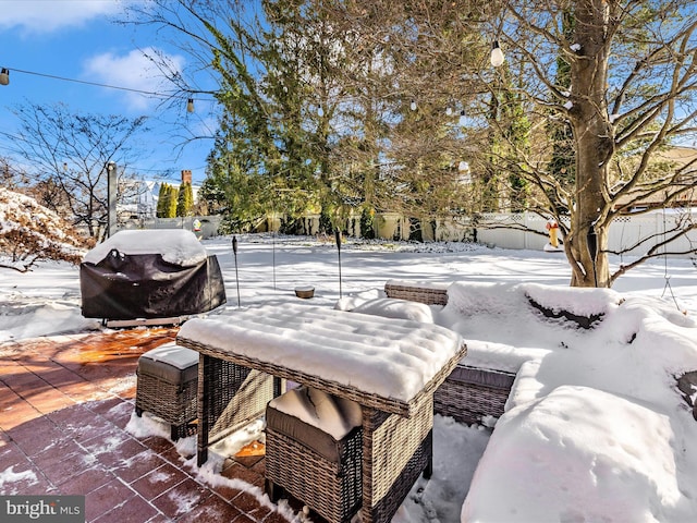 yard layered in snow featuring a patio area