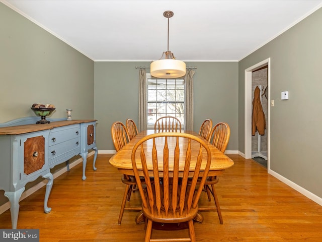 dining space with light hardwood / wood-style floors and ornamental molding