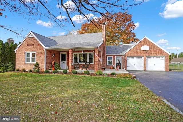 view of front of property with a front yard, a porch, and a garage