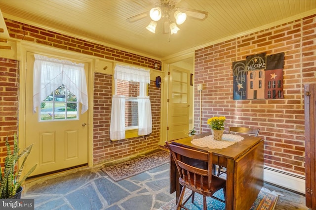 dining room with crown molding, ceiling fan, and brick wall