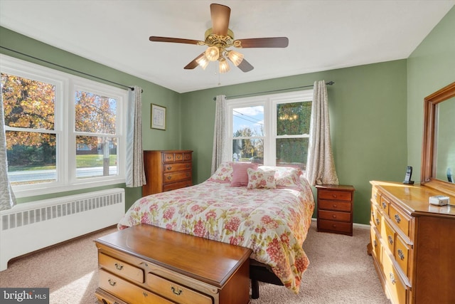 carpeted bedroom with radiator and ceiling fan