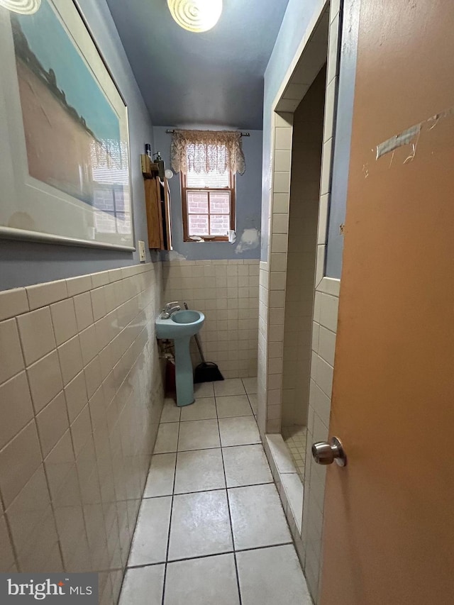 bathroom with tile patterned flooring, tile walls, and sink