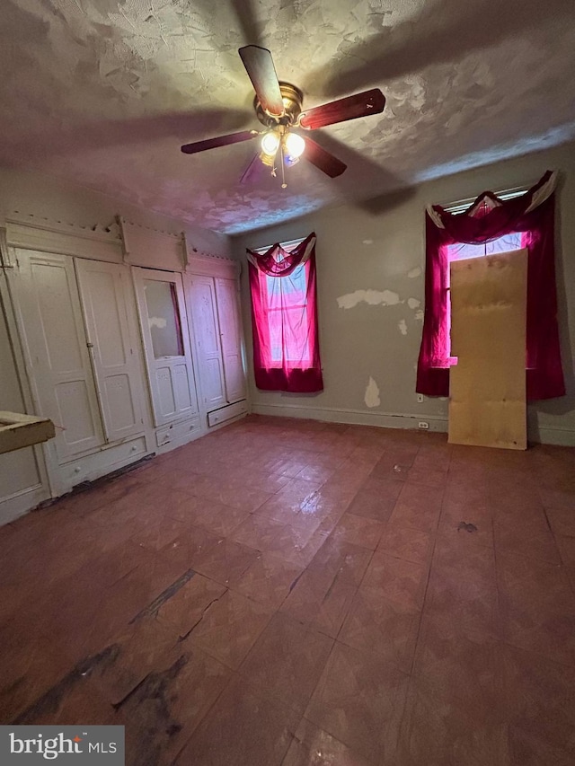 unfurnished bedroom featuring a textured ceiling and ceiling fan