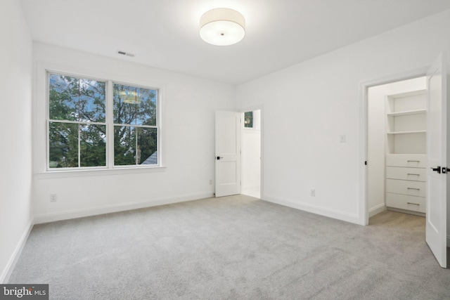 unfurnished bedroom featuring light colored carpet and multiple windows