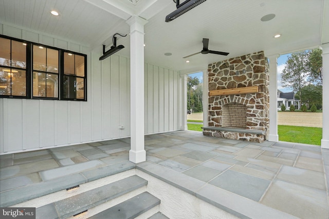 view of patio with an outdoor stone fireplace and ceiling fan