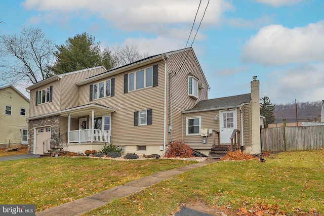 view of front of house featuring a front lawn, covered porch, and a garage