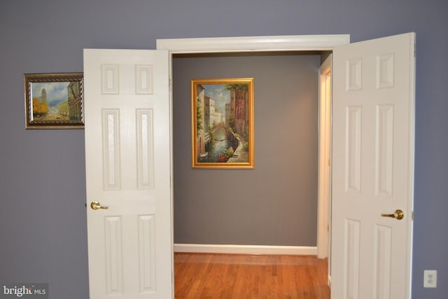 hallway with wood finished floors and baseboards