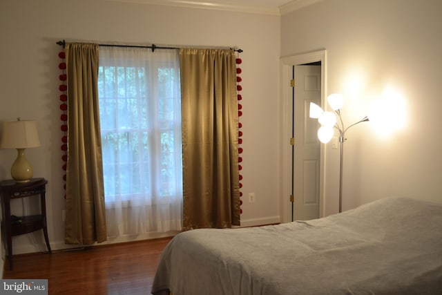 bedroom featuring ornamental molding and wood finished floors