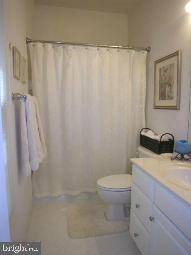 full bathroom featuring a shower with shower curtain, toilet, and vanity