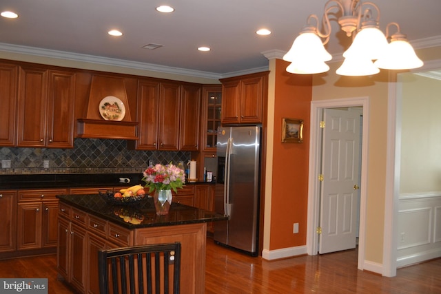 kitchen with a notable chandelier, stainless steel refrigerator with ice dispenser, dark wood-style floors, crown molding, and decorative backsplash