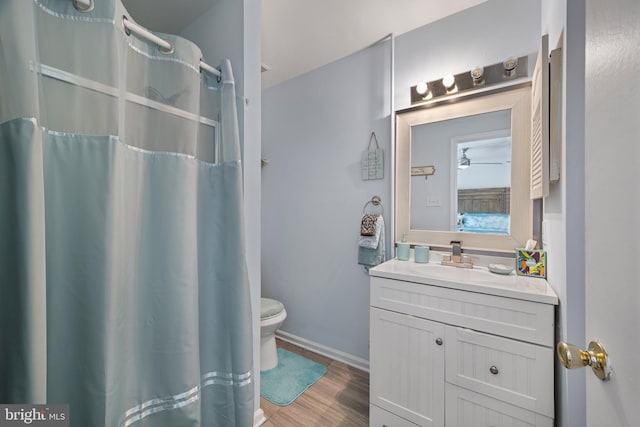 bathroom featuring ceiling fan, hardwood / wood-style floors, vanity, and toilet