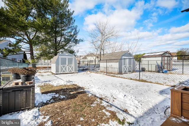 yard covered in snow with a shed