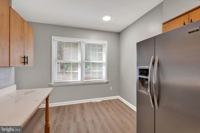 kitchen with stainless steel refrigerator with ice dispenser and light hardwood / wood-style floors