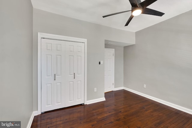 unfurnished bedroom featuring a closet, ceiling fan, and dark hardwood / wood-style flooring