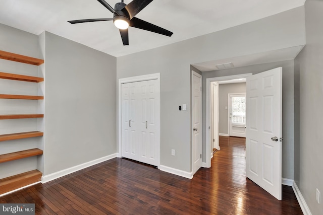 unfurnished bedroom with ceiling fan and dark hardwood / wood-style floors