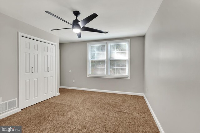 unfurnished bedroom featuring ceiling fan, carpet floors, and a closet