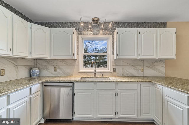 kitchen featuring light stone countertops, sink, stainless steel dishwasher, backsplash, and white cabinets