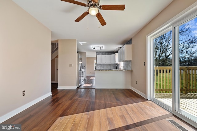 kitchen featuring decorative backsplash, kitchen peninsula, ceiling fan, white cabinets, and dark hardwood / wood-style floors