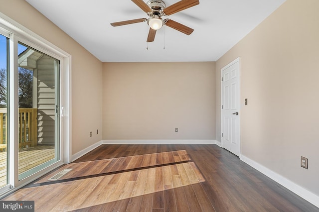 empty room with dark hardwood / wood-style flooring and ceiling fan