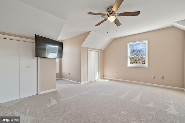 additional living space with light colored carpet, ceiling fan, and lofted ceiling