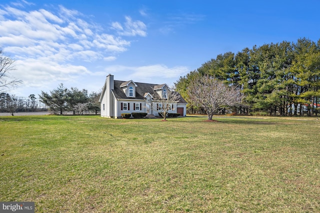 new england style home featuring a front yard and a garage