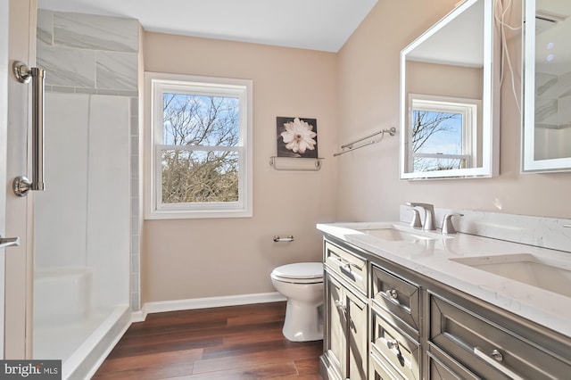 bathroom featuring walk in shower, hardwood / wood-style floors, vanity, and toilet