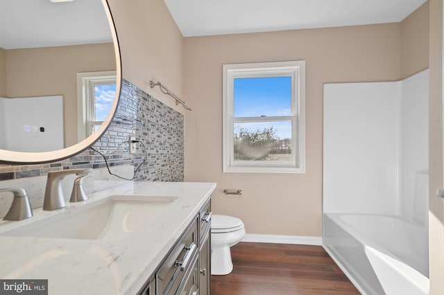 full bathroom featuring toilet, shower / tub combination, decorative backsplash, vanity, and hardwood / wood-style flooring