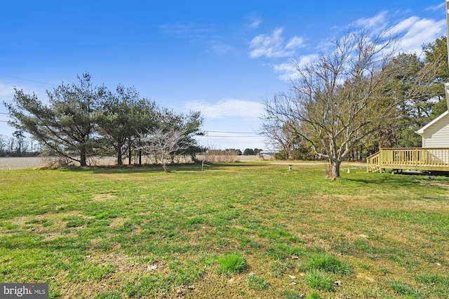 view of yard with a rural view and a deck