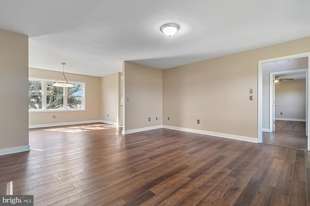 empty room featuring ceiling fan and dark hardwood / wood-style flooring